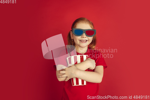 Image of Caucasian little girl portrait isolated on red studio background, emotions concept