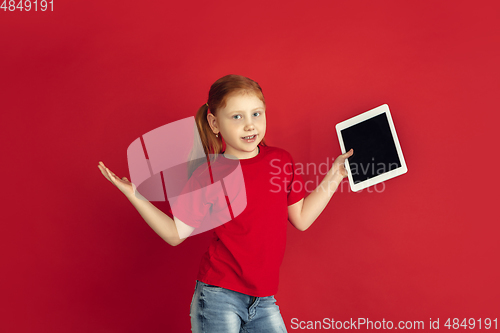 Image of Caucasian little girl portrait isolated on red studio background, emotions concept