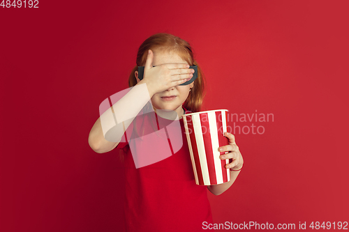 Image of Caucasian little girl portrait isolated on red studio background, emotions concept