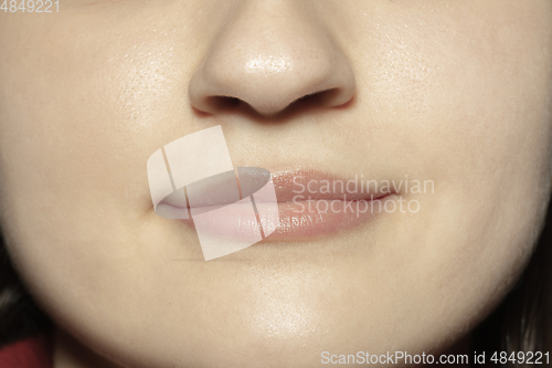 Image of Close-up female mouth with natural nude gloss lips make-up. Cosmetology, dentistry and beauty care, emotions