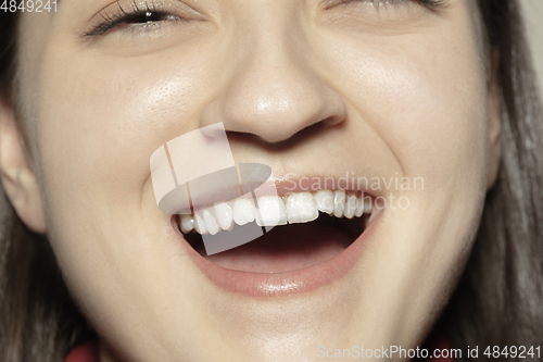 Image of Close-up female mouth with natural nude gloss lips make-up. Cosmetology, dentistry and beauty care, emotions