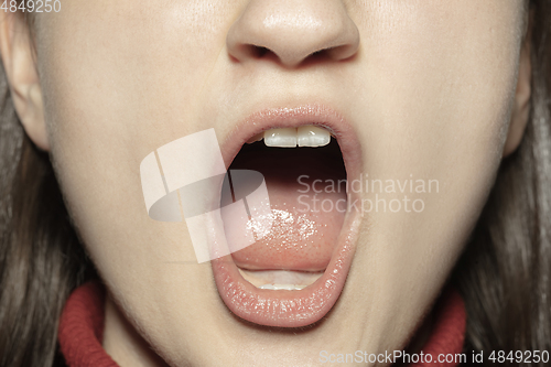 Image of Close-up female mouth with natural nude gloss lips make-up. Cosmetology, dentistry and beauty care, emotions