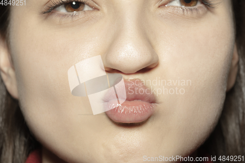 Image of Close-up female mouth with natural nude gloss lips make-up. Cosmetology, dentistry and beauty care, emotions