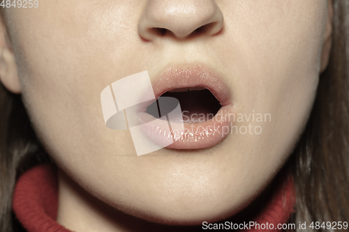 Image of Close-up female mouth with natural nude gloss lips make-up. Cosmetology, dentistry and beauty care, emotions