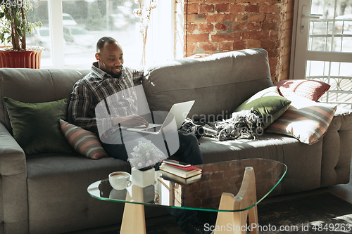 Image of African-american man, freelancer during the work in home office while quarantine
