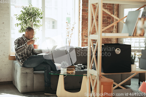 Image of African-american man, freelancer during the work in home office while quarantine