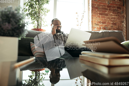 Image of African-american man, freelancer during the work in home office while quarantine