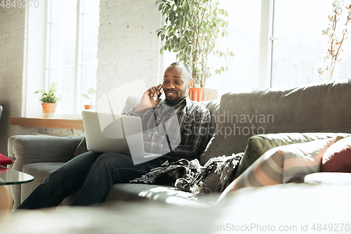 Image of African-american man, freelancer during the work in home office while quarantine