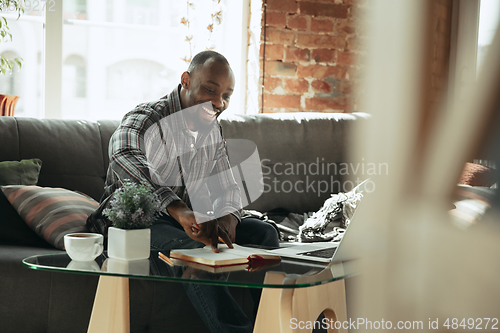 Image of African-american man, freelancer during the work in home office while quarantine