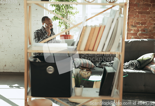 Image of African-american man, freelancer during the work in home office while quarantine