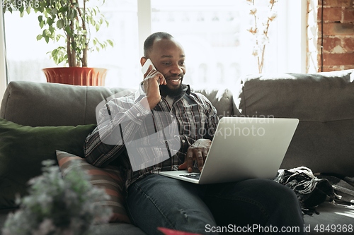 Image of African-american man, freelancer during the work in home office while quarantine