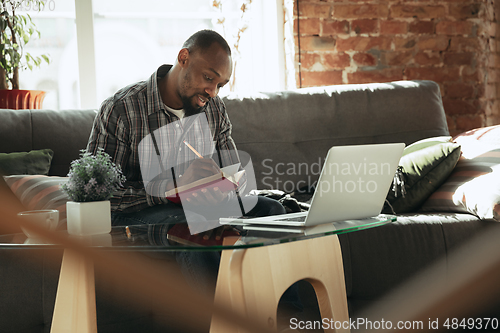 Image of African-american man, freelancer during the work in home office while quarantine