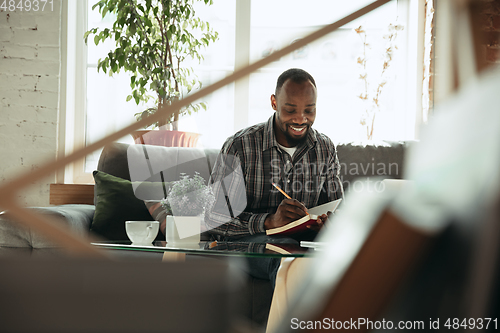 Image of African-american man, freelancer during the work in home office while quarantine