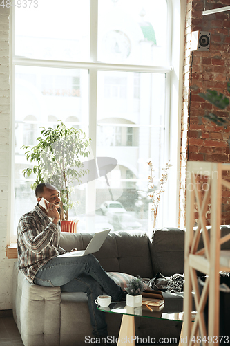 Image of African-american man, freelancer during the work in home office while quarantine