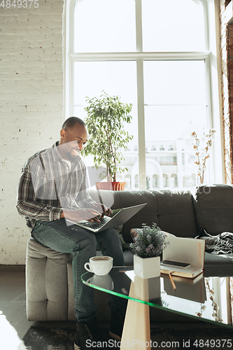 Image of African-american man, freelancer during the work in home office while quarantine