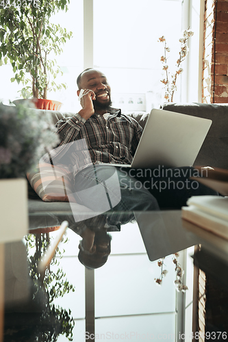 Image of African-american man, freelancer during the work in home office while quarantine