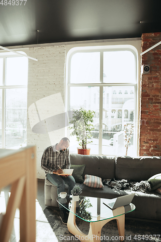 Image of African-american man, freelancer during the work in home office while quarantine