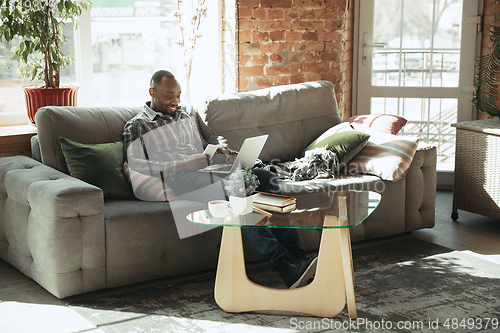 Image of African-american man, freelancer during the work in home office while quarantine