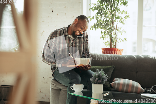 Image of African-american man, freelancer during the work in home office while quarantine