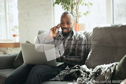 Image of African-american man, freelancer during the work in home office while quarantine