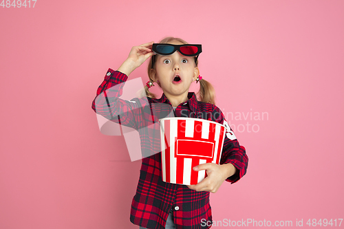Image of Caucasian little girl\'s portrait on pink studio background, cinema concept