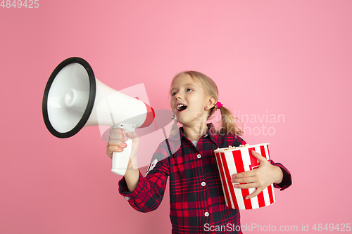 Image of Caucasian little girl\'s portrait on pink studio background, cinema concept