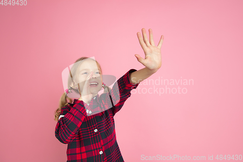 Image of Caucasian little girl\'s portrait on pink studio background