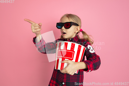 Image of Caucasian little girl\'s portrait on pink studio background, cinema concept