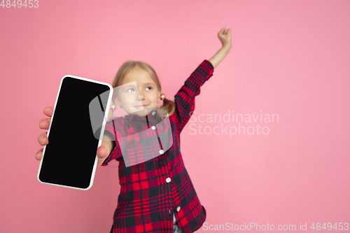 Image of Caucasian little girl\'s portrait on pink studio background