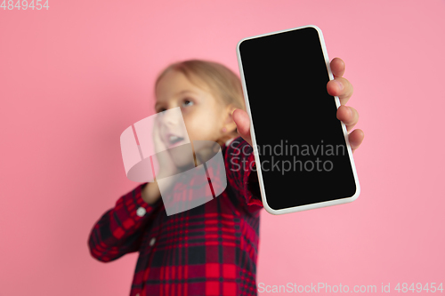 Image of Caucasian little girl\'s portrait on pink studio background