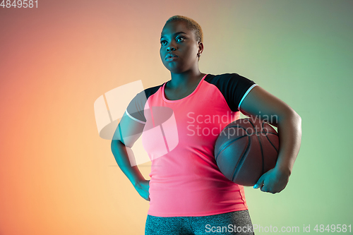 Image of Young african-american plus size female model\'s training on gradient background