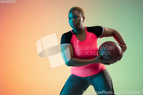 Image of Young african-american plus size female model\'s training on gradient background