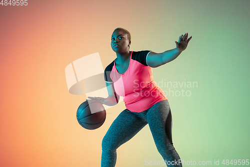 Image of Young african-american plus size female model\'s training on gradient background