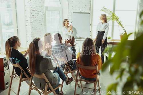 Image of Female caucasian speaker giving presentation in hall at university or business centre workshop