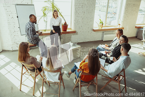 Image of Female caucasian speaker giving presentation in hall at university or business centre workshop