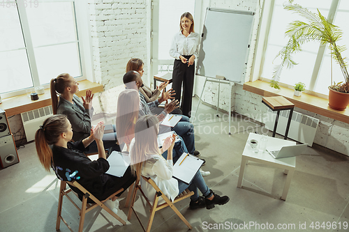 Image of Female caucasian speaker giving presentation in hall at university or business centre workshop
