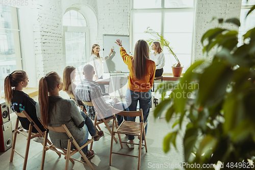 Image of Female caucasian speaker giving presentation in hall at university or business centre workshop