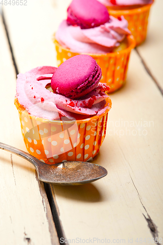 Image of pink berry cream cupcake with macaroon on top