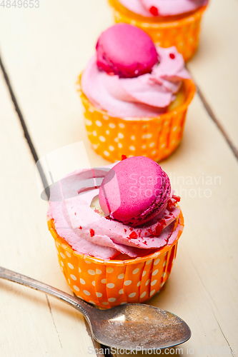 Image of pink berry cream cupcake with macaroon on top