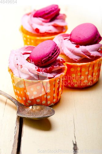 Image of pink berry cream cupcake with macaroon on top