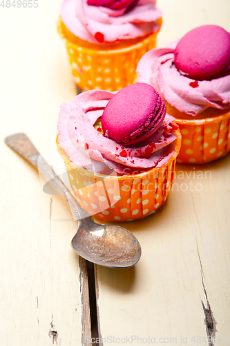 Image of pink berry cream cupcake with macaroon on top