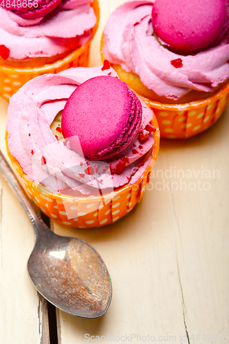 Image of pink berry cream cupcake with macaroon on top