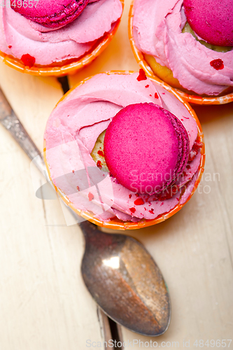 Image of pink berry cream cupcake with macaroon on top