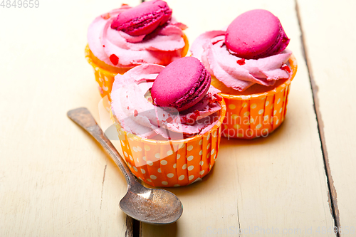 Image of pink berry cream cupcake with macaroon on top