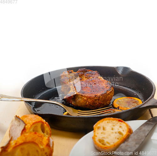 Image of pork chop seared on iron skillet