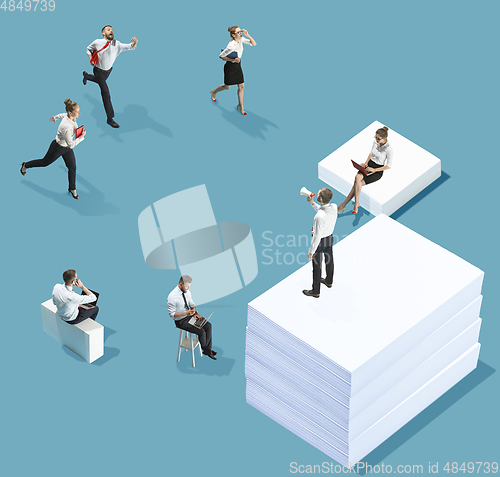 Image of High angle view of creative office on blue background - big things and little workers