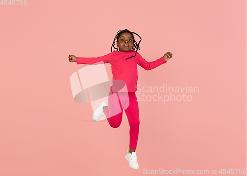 Image of Handsome african little girl portrait isolated on pink studio background with copyspace