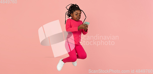 Image of Handsome african little girl portrait isolated on pink studio background with copyspace