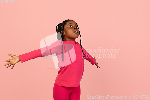 Image of Handsome african little girl portrait isolated on pink studio background with copyspace