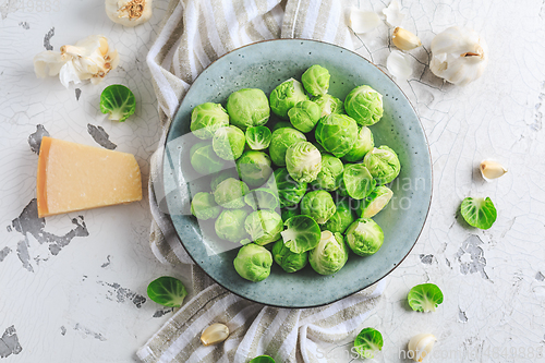 Image of Raw Brussel sprouts with salt and Parmesan cheese in bowl